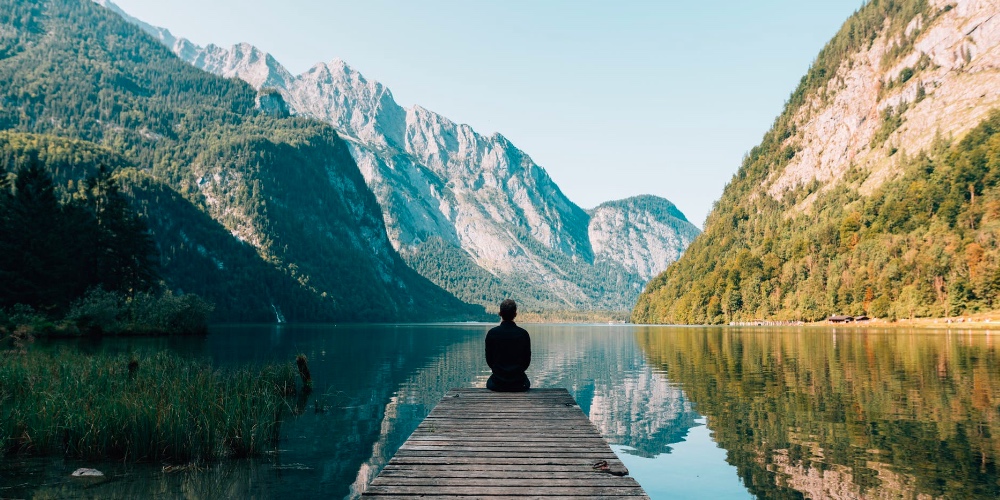 person sitting with view on lake what is karma yoga