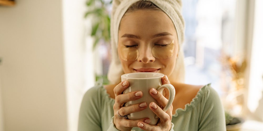 woman holding tea cup health effects of green tea